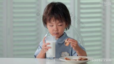 可爱的小男孩喝牛奶吃饼干